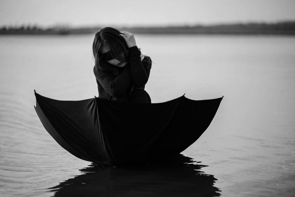 Frau in einem Regenschirm auf dem Wasser.