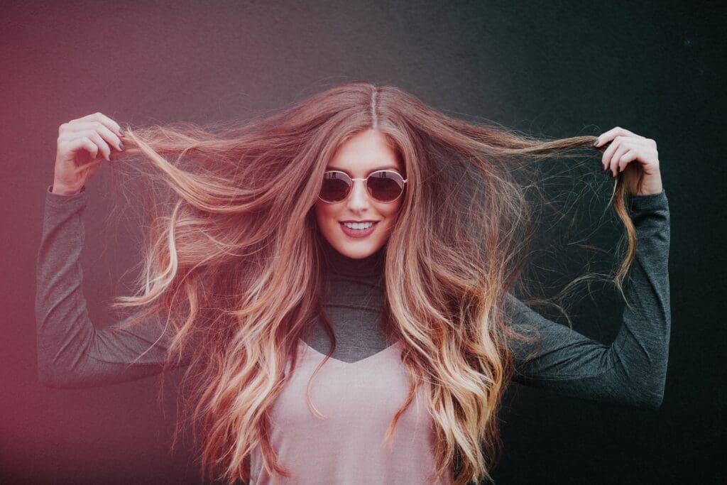 Frau mit Sonnenbrille und langen, gewellten Haaren