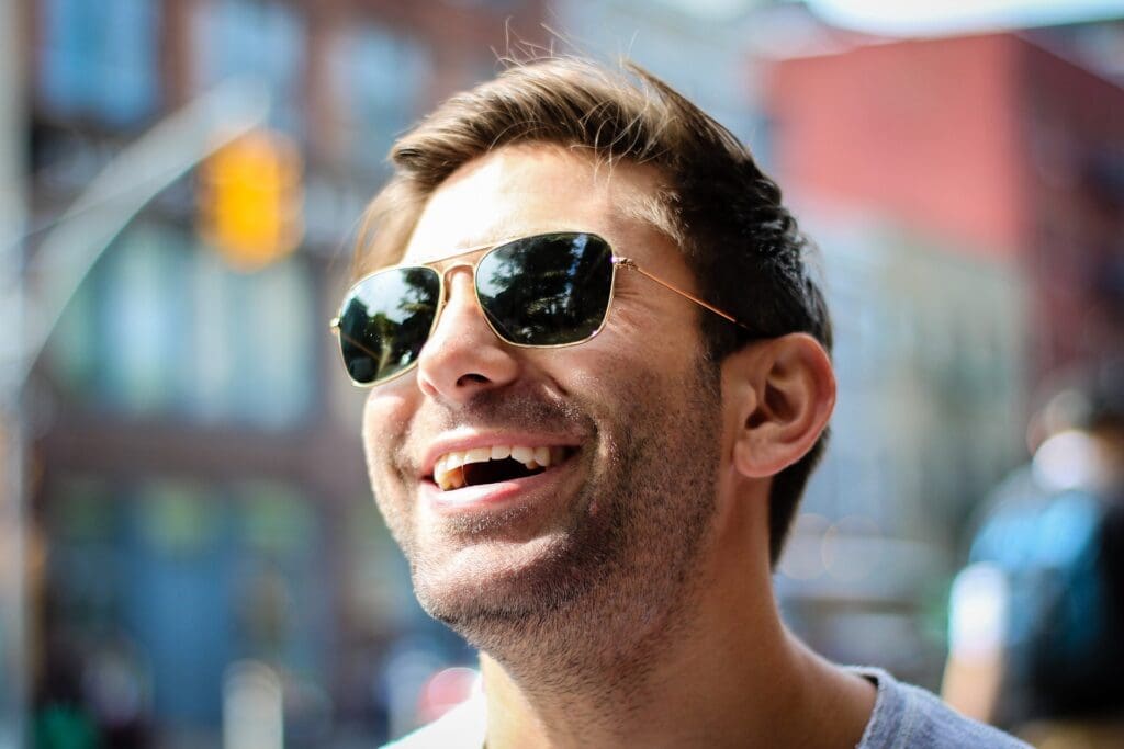 Lachender Mann mit Sonnenbrille im Freien